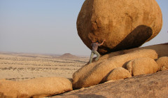 un hombre rodando una piedra gigante